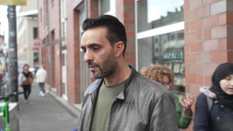 Adel steht vor einem Geschäft 