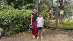 Eine Mutter steht mit ihrem Kind vor einem Gehege im Krefelder Zoo