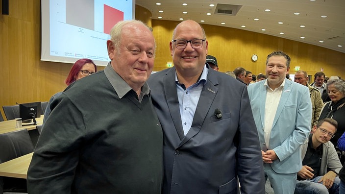 Stefan Hebbel (rechts) steht in einem Parlamentsgebäude. Links von ihm steht sein Vater Paul Hebbel.