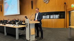 Wahlleiter Alexander Lünenbach steht am Mikrofon