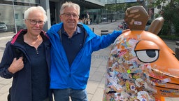 Älteres Ehepaar posiert neben der Maus für ein Foto