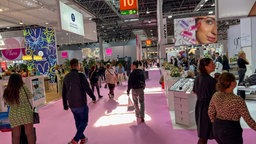 Eine Messehalle in Düsseldorf, auf dem Boden liegt rosaner Teppich, einige Besucher sind zu sehen