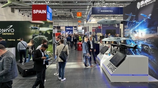 Zu sehen ist die Messehalle mit Besuchern