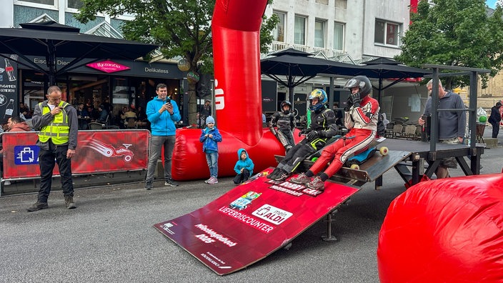 Zwei Rennfahrer mit Bobbycars auf der Startrampe bei der Deutschen Bobbycar-Meisterschaft in Mönchengladbach