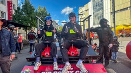 Zwei Rennfahrer mit Bobbycars auf der Startrampe