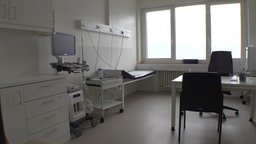 Leere Arztpraxis mit Liege und medizinischen Geräten
