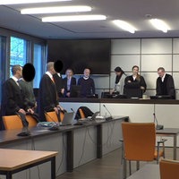 Totale aus dem Gerichtssaal. Angeklagter, Richter und Anwälte stehen an ihren Plätzen.