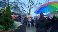 Menschen stehen am Mahnmal neben der Hohenzollernbrücke
