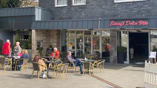 mehrere Gäste in einem Eiscafe