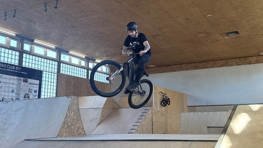 Freestyle Mountainbiker beim Sprung in Halle