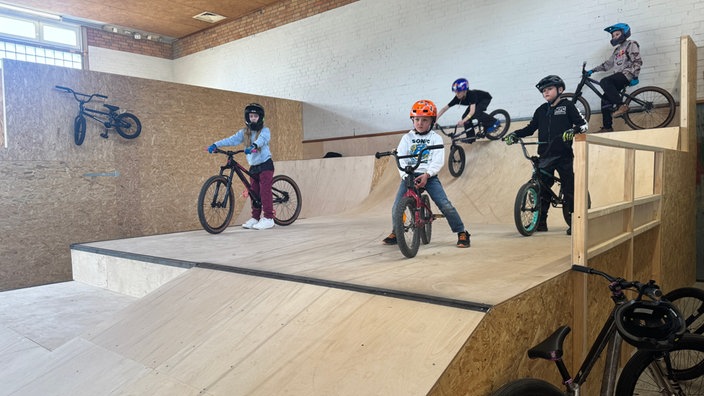Kinder auf Mountainbikes und BMX-Rädern waren auf Holzrampen