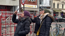Drei Menschen stehen von der Montierung von Lichtelementen und unterhalten sich