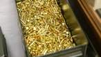 Eine große Metallkiste mit gold glänzender Einzelmunition