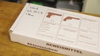 Karton für Beweismittel mit aufgedruckten Pistolen Fotos