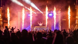 Bühnenshow mit Flammen und Publikum im Vordergrund