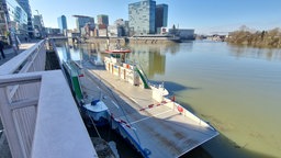 Auf dem Bild sieht man eine Schiff, es liegt im Düsseldorfer Hafen und wird von der Sonne angestrahlt, im Hintergrund sieht man den Düsseldorfer Medienhafen