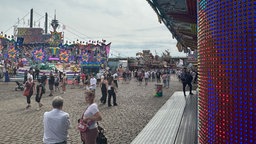 Auf dem ist ein Fußweg der Düsseldorf Rheinkirmes, flankiert von zwei Fahrgeschäften.