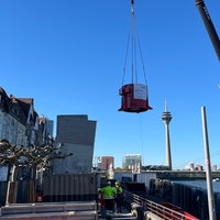 ein Kran transportiert einen Ventilator am Rhein-Ufer