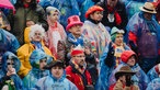Viele verkleidete Menschen, einige tragen Regencapes.