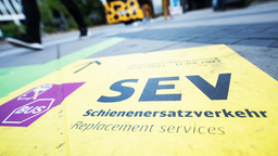 Bodenmarkierung mit Symbolbild (durchgestrichener Zug) und Hinweistext "Schienenersatzverkehr"
