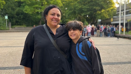 Mutter und Sohn lächeln in die Kamera