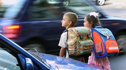 Kinder warten vor einer Straße
