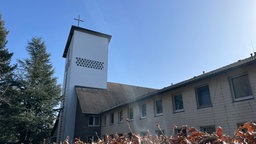 Ein Kirchturm vor blauem Himmel.