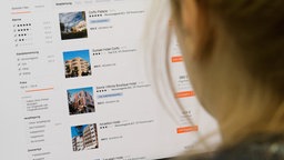 Auf dem Foto ist eine Frau, die am Computer Hotelangebote vergleicht