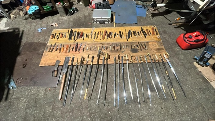 Hieb und Stichwaffen, Messer, Säbel, auf einer Holzuntzerlage
