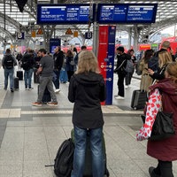 Bahnkunden warten am Gleis auf den nächsten Zug