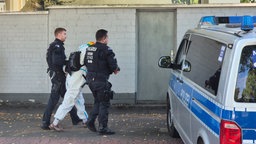 Aktivisten vom Antikriegsbündnis "Rheinmetall Entwaffnen", die den Zugang zu einem Gebäude der Bundeswehr blockieren, werden von Polizisten abgeführt