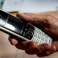 Senior hält Telefon in der Hand