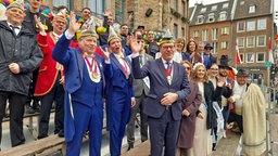Gruppenfoto auf der noch leeren Karnevalstribüne am Düsseldorfer Rathaus mit Jecken aus Düsseldorf, Teneriffa und OB Keller 