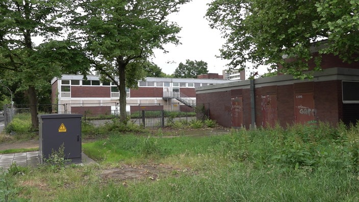 Blick auf ein verlassenes, verwahrlostes Schulgebäude in Köln-Worringen.
