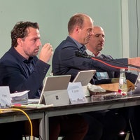 Drei Männer und eine Frau sitzen an einem Tisch