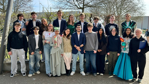Die Schülerinnen und Schüler stehen in zwei Reihen draußen.