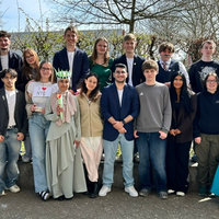 Die Schülerinnen und Schüler stehen in zwei Reihen draußen.