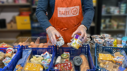Symbolbild: Ein Tafel-Mitarbeiter füllt Körbe mit Lebensmitteln