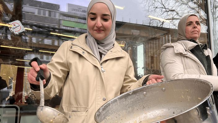 Eine Frau hält eine Suppenkelle in der Hand