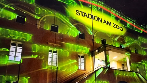 Die mit grünem Licht beleuchtete Front des Stadion am Zoo in Wuppertal.