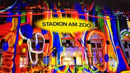 Die Front vom Stadion am Zoo in Wuppertal mit buntem Lichtspiel beleuchtet.