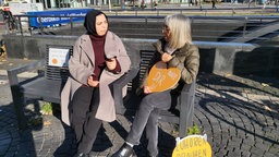 Zwei Frauen sitzen auf einer Bank