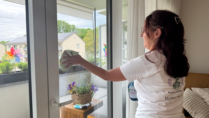 Frau putzt Fenster 