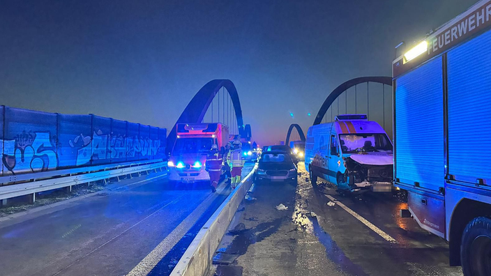 Zwei der Unfallwögen sowie die Feuerwehr stehen nach der Karambolage auf der Strecke der A42