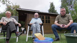 Johann Knobe, Hans-Joachim Olschewski und Ulf Bergmann sitzen in Knobes Garten und haben eine Falle für Hornissen im Blick