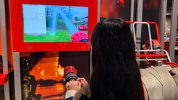 Ein Mädchen probiert sich an einem Löschsimulator aus