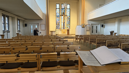 Der Innenraum der Autobahn Kirche. Mehrere Sitzreihen sind zu einem Altar ausgerichtet