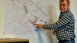 Eine Person zeigt auf eine Landkarte mit markierungen