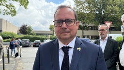 Das Bild zeigt Oberbürgermeister Thomas Kufen vor dem Berufskolleg in Essen.