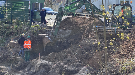 grüner Bagger buddelt die Erde aus